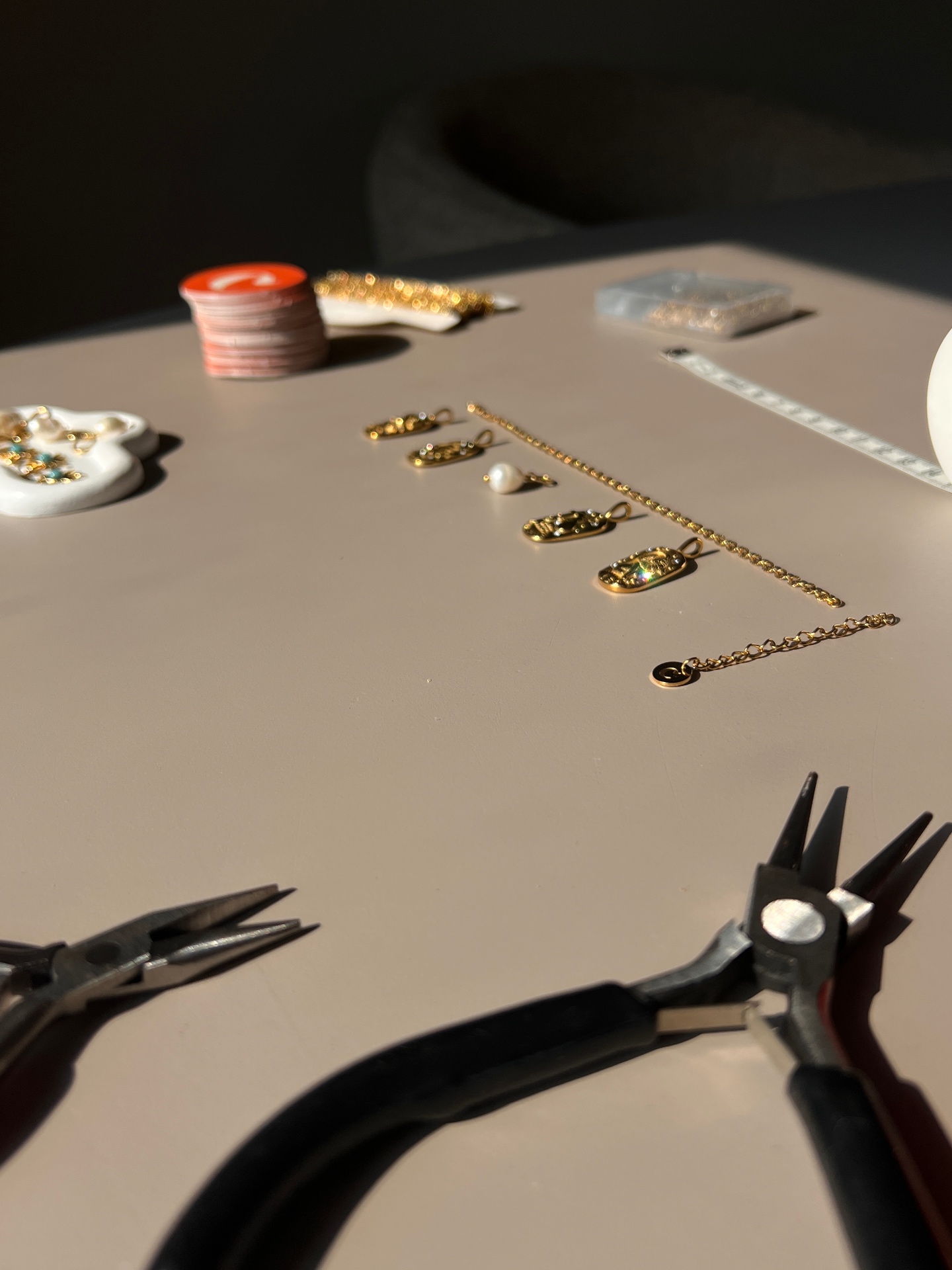 Gouden ketting met bedels op de werktafel
